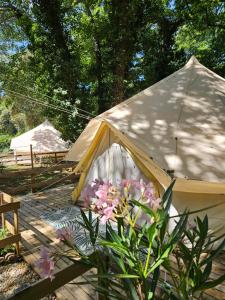 a yellow tent with flowers on a wooden deck at Domaine Authentique de Rose in Porto-Vecchio