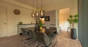 a kitchen and dining room with a table and chairs at Forest Lodge 6 persons #624 in Maasbree