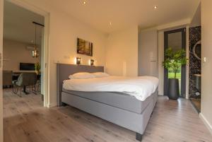 a bedroom with a large bed and a dining room at Forest Lodge 6 persons #624 in Maasbree