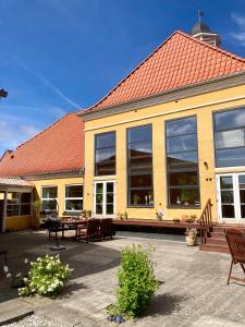 a large yellow building with a red roof at Børglum Mejeri Hotel B&B in Børglum