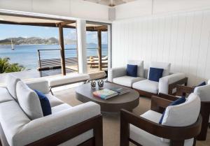 a living room with white furniture and a view of the ocean at Hotel Christopher Saint Barth in Pointe Milou