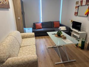 a living room with a couch and a table at A&R Isla de la Palma in San Sebastián de los Reyes