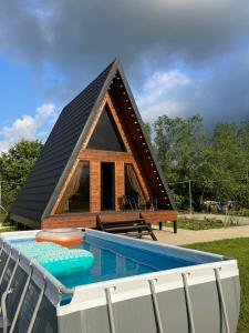 a cabin with a thatched roof and a swimming pool at Aba Ula in Martvili +10 photos