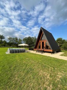 a small house with a black roof in a field at Aba Ula in Martvili