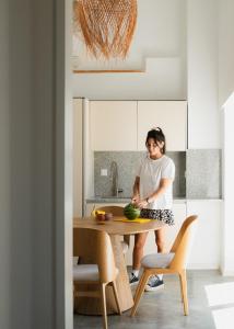 a woman standing at a table in a kitchen at Outsite Ericeira - Boavista in Ericeira +54 photos