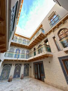 a large building with a balcony and a building at Amina Hotel PREMIUM in Bukhara