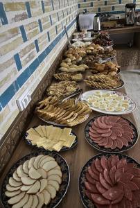 a row of plates of food on a table at Amina Hotel PREMIUM in Bukhara