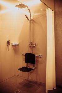 a shower with a chair in a bathroom at Pension Sommer in Waldsassen +23 photos