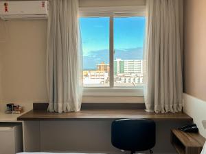 a room with a window with a desk and a chair at Swan Rio Grande in Rio Grande