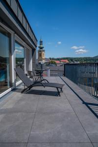 a balcony with a bench and a clock tower at DAS ANTON - Penthouse mit Seeblick und kostenloser Garage in Gmunden