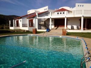 a large swimming pool in front of a house at Villa Corsua in Valle de Guadalupe
