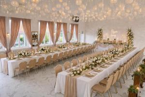 a banquet hall with long tables and chairs with flowers at PLATINIUM House ex Royal House in Białogard