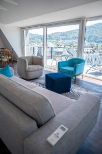 a living room with a couch and a large window at DAS ANTON - Penthouse mit Seeblick und kostenloser Garage in Gmunden