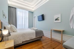 ein Schlafzimmer mit Bett, Tisch und Fernseher in der Unterkunft SAL Collection Hotel in Aveiro