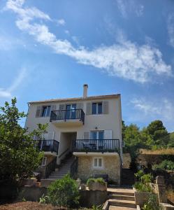 a white house with stairs in front of it at Apartman Prošperino in Vis