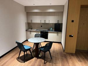 a small kitchen with a table and chairs in a room at Paziro Hotel in Dushanbe