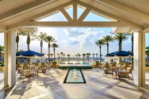an outdoor patio with tables and chairs and palm trees at Omni Amelia Island Resort & Spa in Amelia Island
