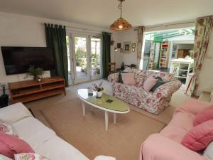 a living room with two couches and a tv at The Garden Rooms in Narberth