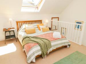 a bedroom with a large bed with a skylight at The Garden Rooms in Narberth