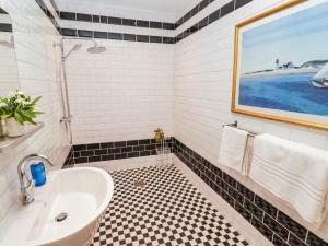 a bathroom with a bath tub and a sink at The Garden Rooms in Narberth +19 photos