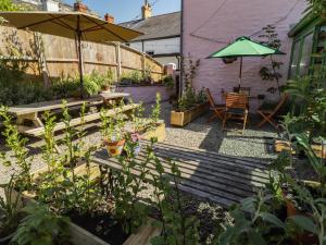 a garden with a bench and a table and an umbrella at The Garden Rooms in Narberth