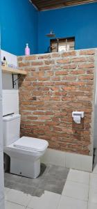 a bathroom with a brick wall and a toilet at Hidden Valley Backpackers in Iringa +71 photos