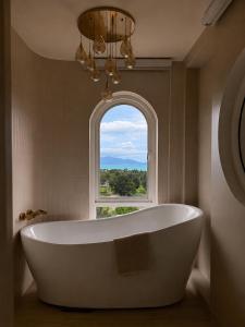a bath tub in a bathroom with a window at CASA MARINe in Bophut