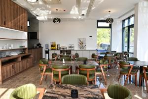 a dining room with tables and green chairs at Velmare Inn in Ulcinj