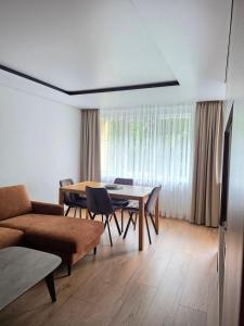 a living room with a table and a couch at Central Apartament in Telšiai