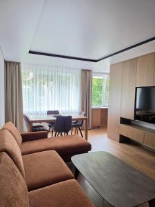 a living room with a couch and a table at Central Apartament in Telšiai