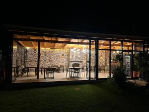 a glass extension of a house with tables and chairs at Mosaic Guesthouse in Lin