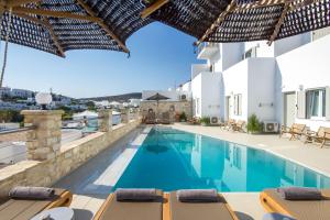 eine Villa mit Swimmingpool und Liegestühlen in der Unterkunft Paliomylos Spa Hotel in Naoussa