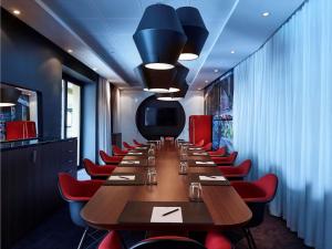 a long table in a restaurant with red chairs at Navera Phuket - MGallery Collection in Surin Beach +46 photos