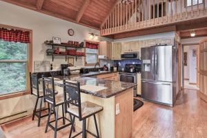 a kitchen with a refrigerator and some bar stools at Charming 4BR Cabin - HOT TUB - Mountain View in Hoyes Run +22 photos