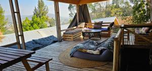 a porch with a couch and a table on a deck at Hidden Valley Backpackers in Iringa