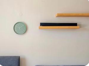 a clock on a white wall with a shelf and a clock at Apex Residence The Lake Merrit Hause in Oakland