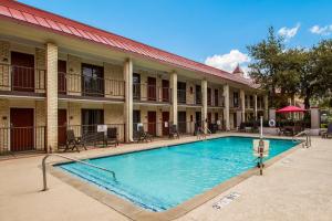 a large swimming pool in front of a building at Red Roof Inn PLUS+ Dallas - Addison in Addison
