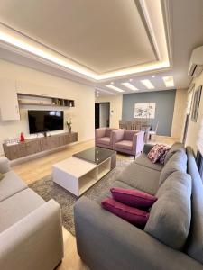 ein Wohnzimmer mit Sofa und Tisch in der Unterkunft Elite Residence - Koura , Near Tripoli in An Nakhlah