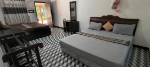 a bedroom with a bed and a chair in it at Nilaveli Beach Rooms in Nilaveli +166 photos