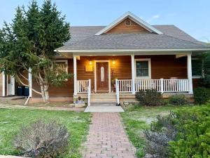 a house with a front porch with a tree at The Gathering Place home in Montrose