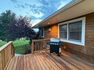 a grill on a wooden deck next to a house at The Gathering Place home in Montrose