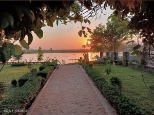 a pathway in front of a lake at sunset at Mwanati Executive Lodge in Liwonde