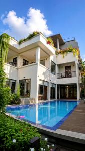 a building with a swimming pool in front of it at Dhanora Dynasty Resort in Anuradhapura