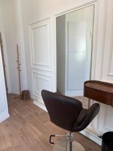 a black chair sitting in a room with a door at Mendess suites in Palaiseau