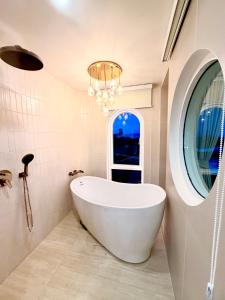 a bath tub in a bathroom with a window at CASA MARINe in Bophut