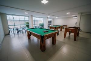 a room with three pool tables and chairs at Varadero Palace Hotel in Florianópolis