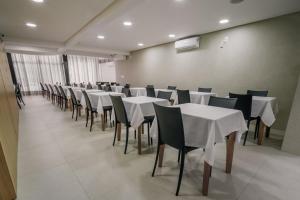 a dining room with white tables and chairs at Varadero Palace Hotel in Florianópolis +57 photos