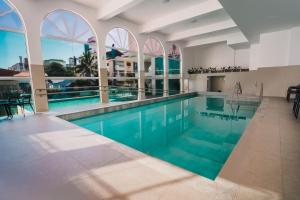 a swimming pool with blue water in a building at Varadero Palace Hotel in Florianópolis
