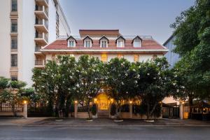 a large building with trees in front of it at Central Mansions Hotel and Apartments in Phnom Penh