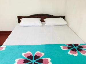 a bed with two pillows on top of it at Sansa HomeStay in Bandarawela